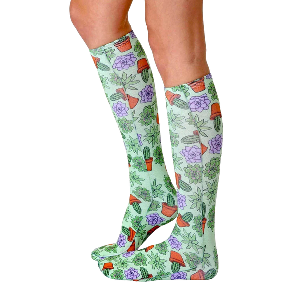 Lifestyle photo showing the Green Thumb socks on a woman's legs from the side. [lf]