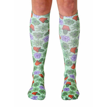 green knee-high sock with cacti and succulent pot design, available for men and women.  