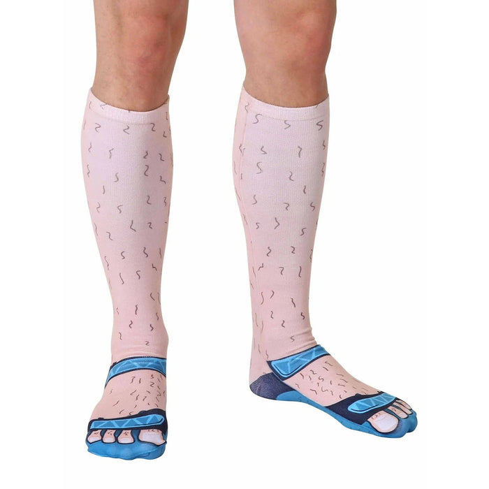 A pair of flesh-colored socks that are printed to look like a pair of hairy legs and feet wearing blue sandals.