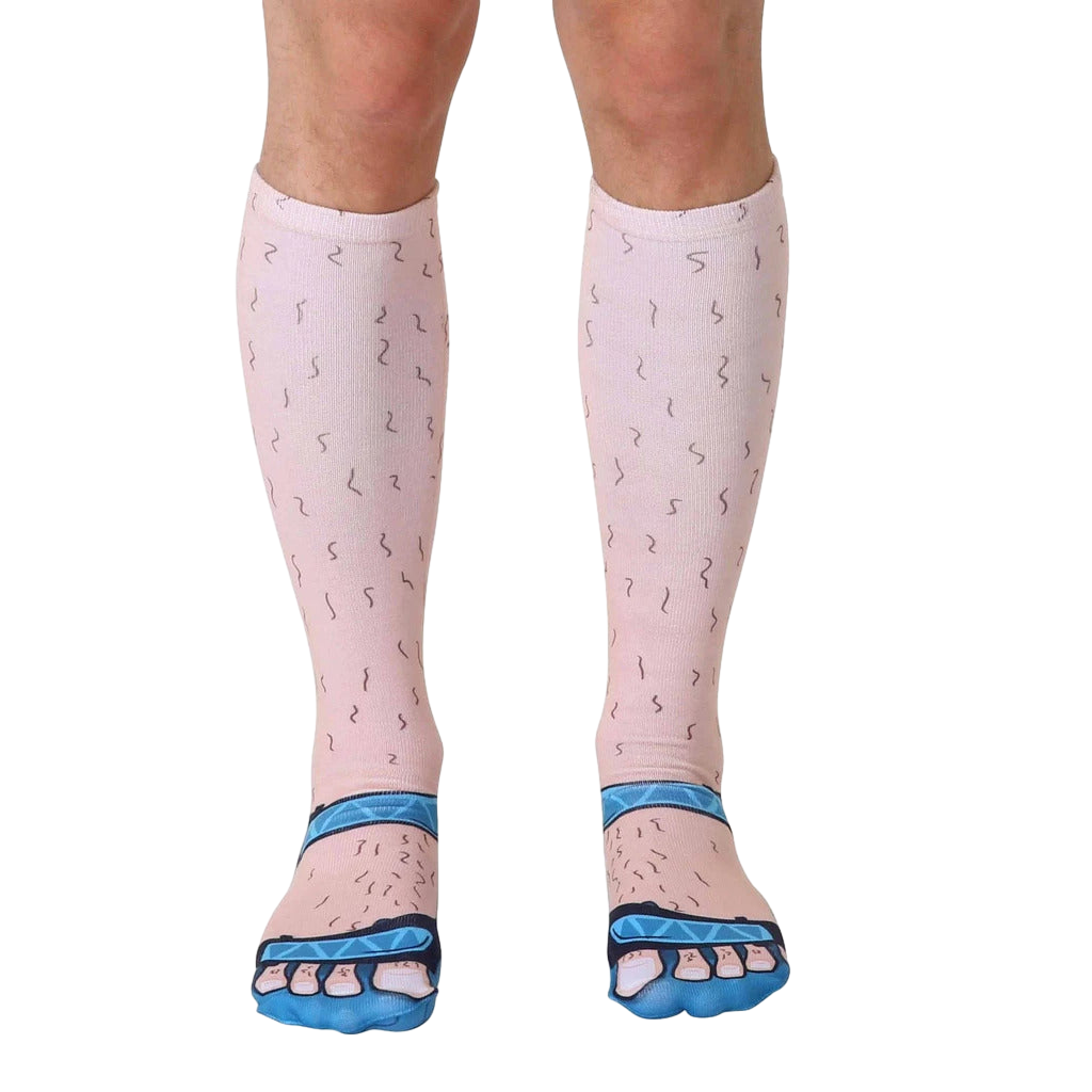 Pair of knee-high socks depicting hairy legs in light beige and blue sandals.  A humorous and unique design. [lf]