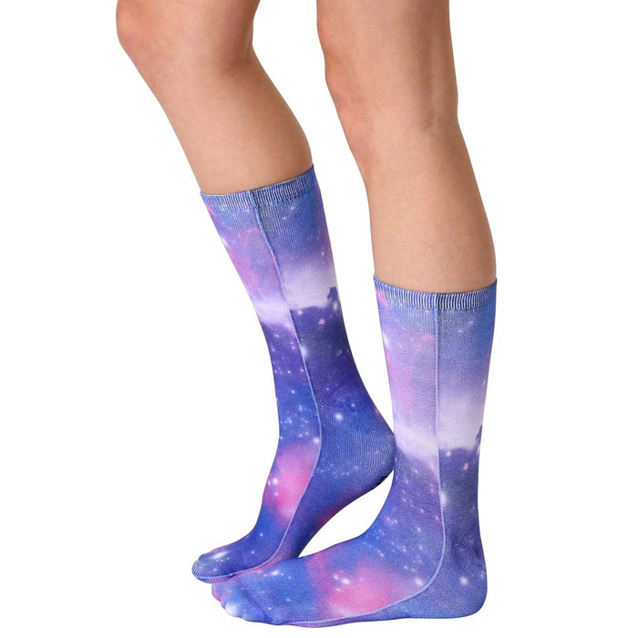 A pair of calf-high socks with a blue and purple galaxy pattern.
