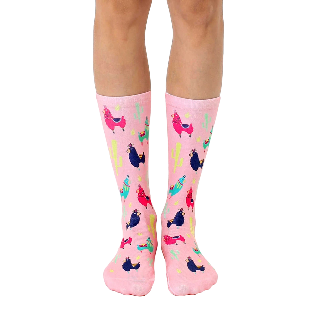 Pink crew socks with a fun pattern of colorful llamas and cacti. [lf]