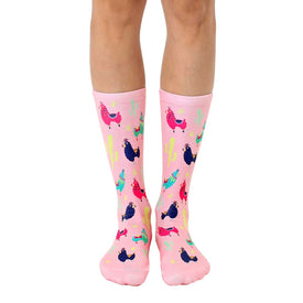 women's crew socks in pink showcasing blue, green, yellow, and pink llamas wearing colorful saddles. cacti with pink flowers are also featured.  