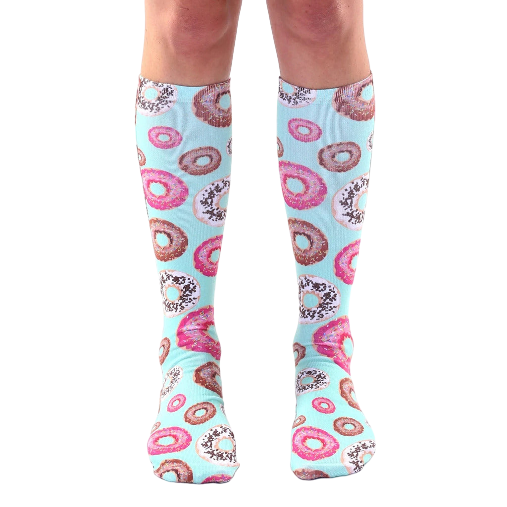 Pair of pastel blue knee-high socks adorned with a pattern of pink and chocolate donut illustrations. [lf]