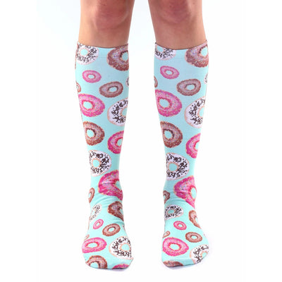 light blue knee-high socks adorned with sprinkled donuts in various colors including pink and brown. unisex sizing.   