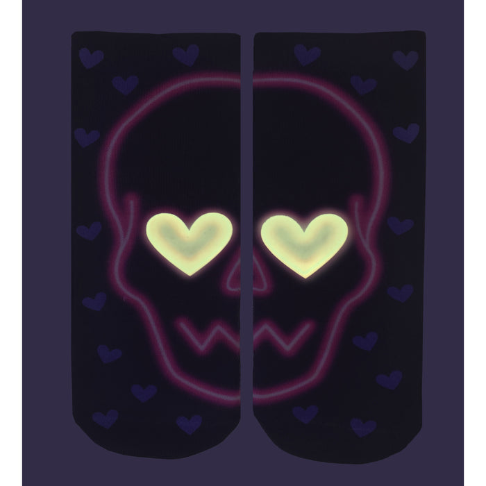 A pair of black socks with a pattern of small purple hearts. The socks also have a large skull design on them. The skull is outlined in pink and has two heart-shaped eyes that are outlined in yellow.