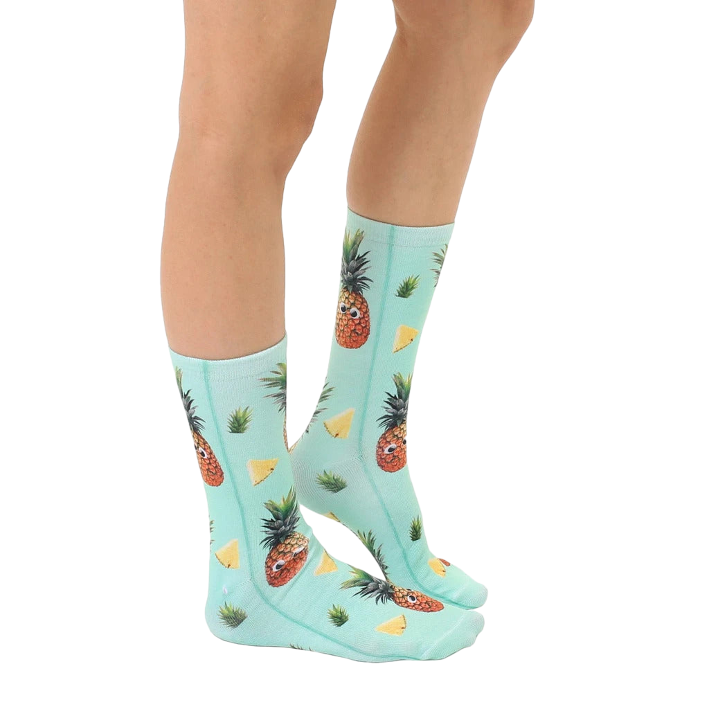 Lifestyle shot: A person's legs wearing the Googly Pineapple socks, showcasing how they look when worn. [lf]