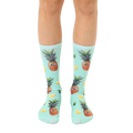 A pair of mint green crew socks with a fun all-over print of googly-eyed pineapples and pineapple wedges. [lf]