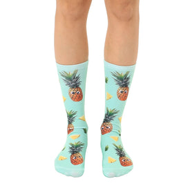 mint green crew socks with a pattern of cartoon pineapples with googly eyes.  