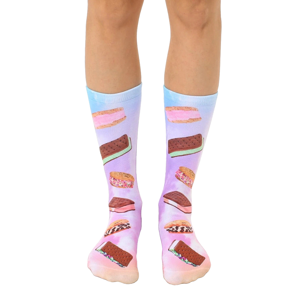 A pair of crew socks with a pastel tie-dye background and colorful ice cream sandwich prints. The socks are mainly pink, purple, and light blue. [lf]