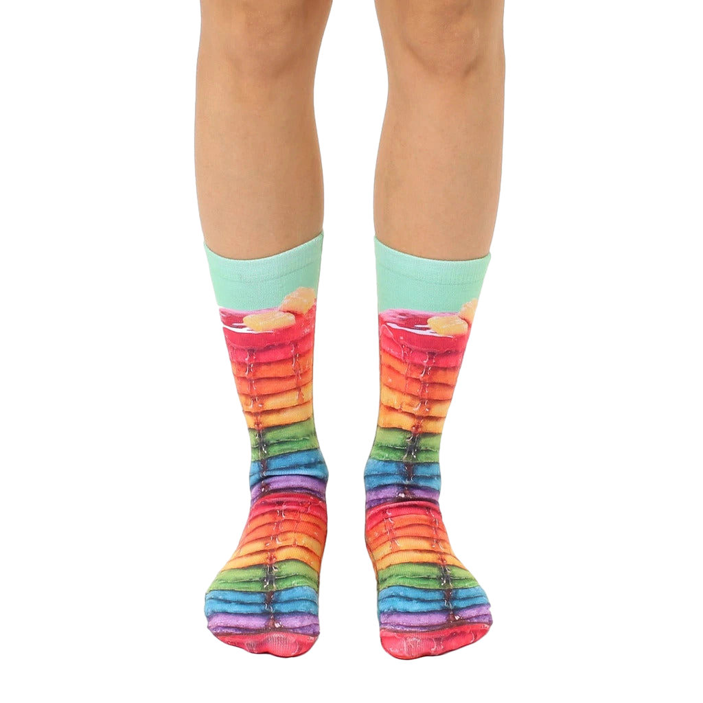 A pair of crew socks showcasing a whimsical design of rainbow-colored pancakes with syrup.  Mint green cuff. [lf]