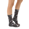 Lifestyle shot showing the T-Rex Fossil socks on a person's legs, from the side, providing a view of the sock pattern. [lf]