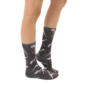 A pair of black socks with a pattern of white dinosaur skeletons.