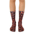 A pair of brown crew socks with an all-over print of coffee beans. Shown on a model's legs. [lf]