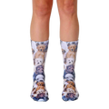 A pair of crew socks covered in an all-over print of adorable puppies in various breeds and colors. The socks are mainly white with brown, tan, and black puppies. [lf]