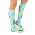 Lifestyle shot showing the Googly Pineapple knee-high socks on a person's legs, showcasing the sock's fit and pattern. [lf]