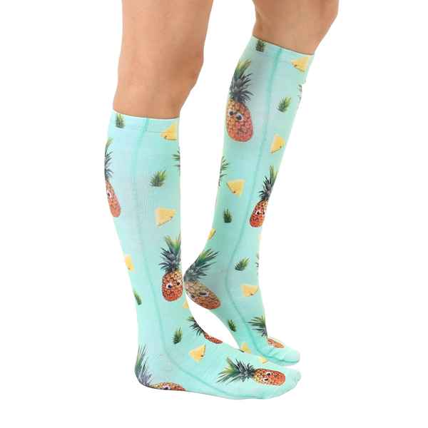 Lifestyle shot showing the Googly Pineapple knee-high socks on a person's legs, showcasing the sock's fit and pattern. [lf]