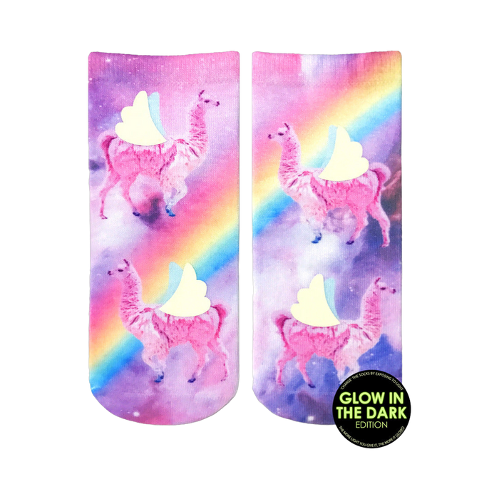 Crew socks showcasing pink llamas with wings against a purple galaxy background featuring a rainbow.  Glow-in-the-dark details.