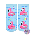 Crew socks featuring pink inflatable flamingos on a light blue wave background. Glitter accents add sparkle. Fun summer design. [lf]
