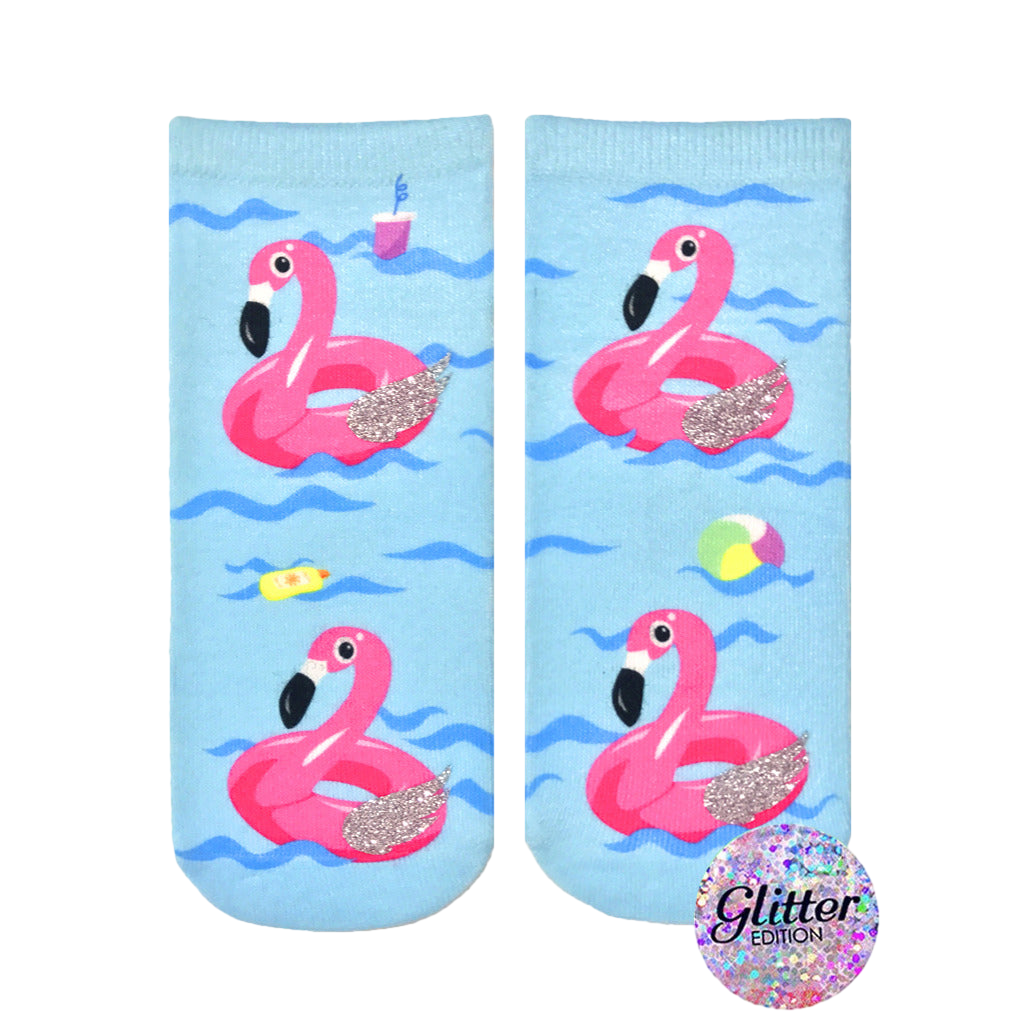 Crew socks featuring pink inflatable flamingos on a light blue wave background. Glitter accents add sparkle. Fun summer design. [lf]