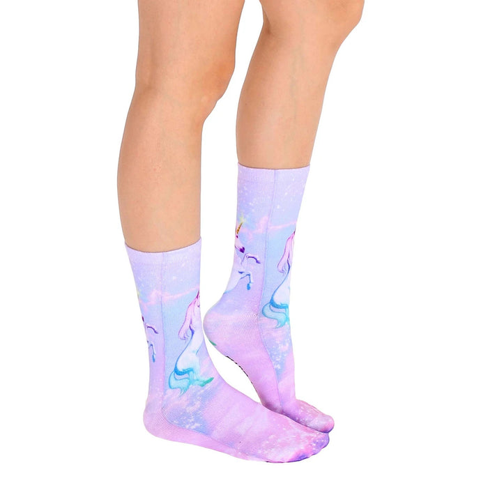 A pair of purple socks with a design of a unicorn with a mermaid tail swimming in a sparkly background.