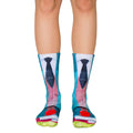 A pair of crew socks with a teacher-themed design: teal, blue, and red, showing a tie, books, and an apple. [lf]