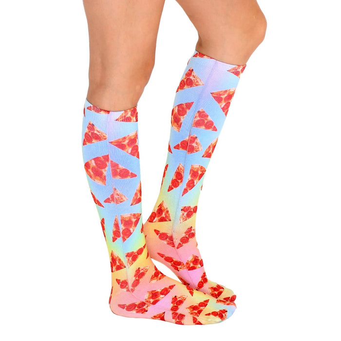 A pair of legs is shown wearing a pair of knee-high socks with a pizza pattern. The socks have a rainbow background and feature slices of pizza.