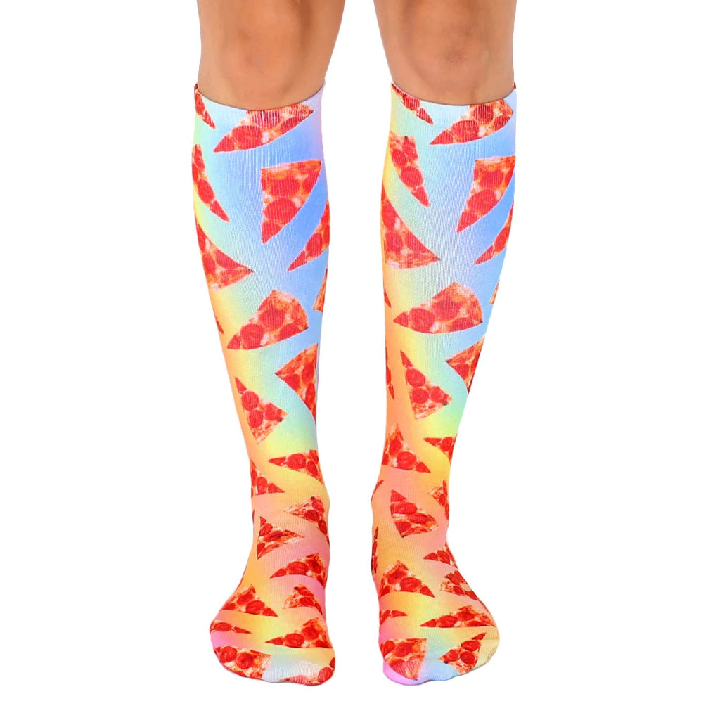 Pair of knee-high socks with a pastel rainbow gradient background featuring repeating images of pepperoni pizza slices. [lf]