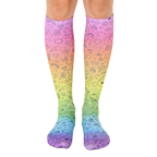 Pair of rainbow gradient knee-high socks with black doodle icons including peace signs, smiley faces, and other fun designs. [lf]