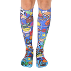A pair of knee-high socks on a model's legs.  The socks are blue with colorful illustrations of summer camp activities, including sports equipment, campfires, and s'mores. [lf]
