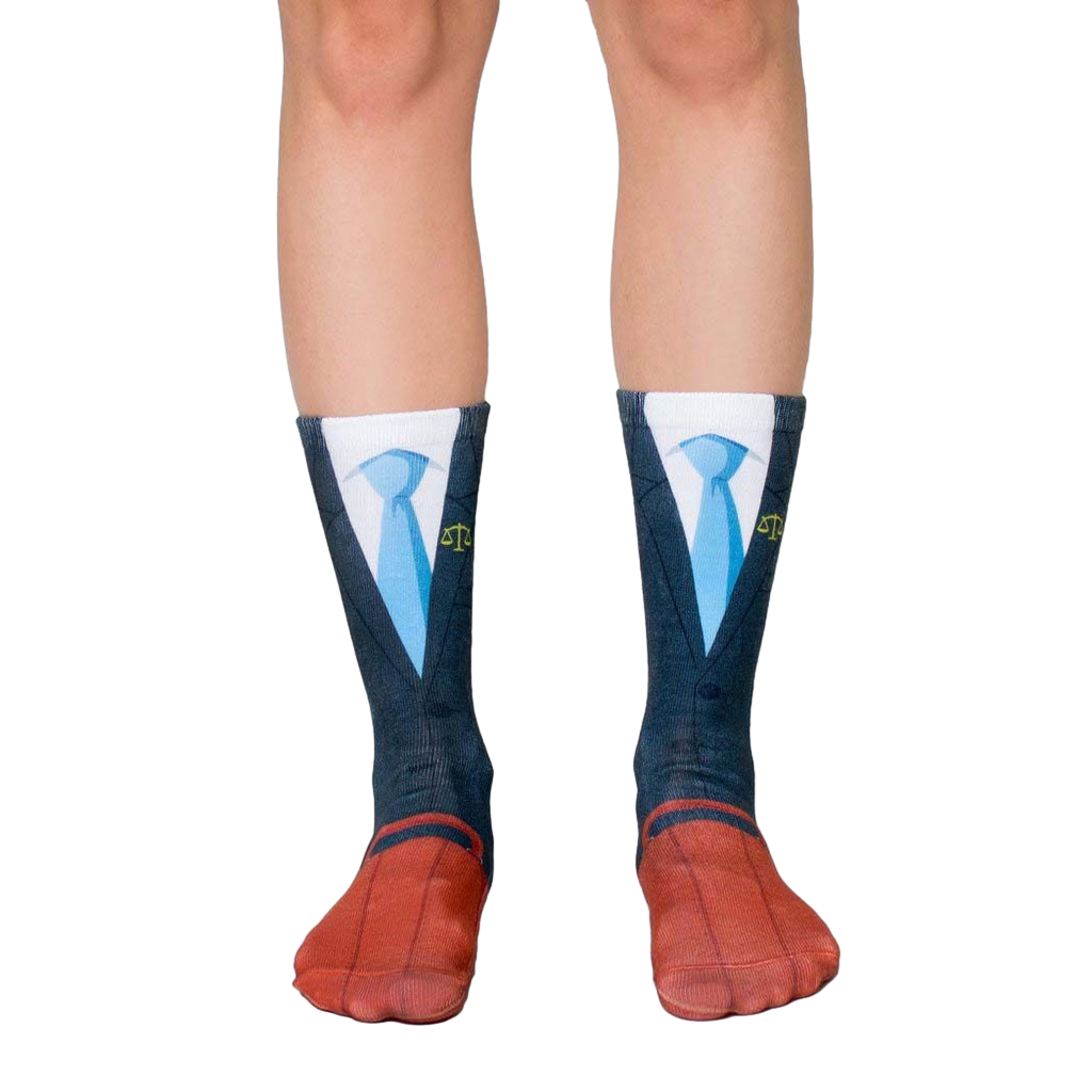 A pair of crew socks showcasing a navy suit and blue tie design.  The socks have red shoe details and yellow scales of justice on the tie. [lf]