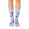 A pair of light blue crew socks with illustrations of various dog breeds.  The socks feature brown, black, and white dog illustrations. [lf]