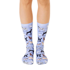 A pair of light blue crew socks with illustrations of various dog breeds.  The socks feature brown, black, and white dog illustrations. [lf]