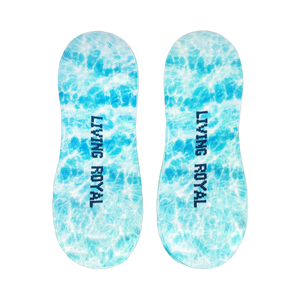 Flat lay image showcasing a pair of light blue no-show socks with a tie-dye effect and the words 'LIVING ROYAL' on them.
