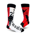 A pair of crew socks. One sock is red with black cats and music notes; the other is white with a piano keyboard and a black cat.