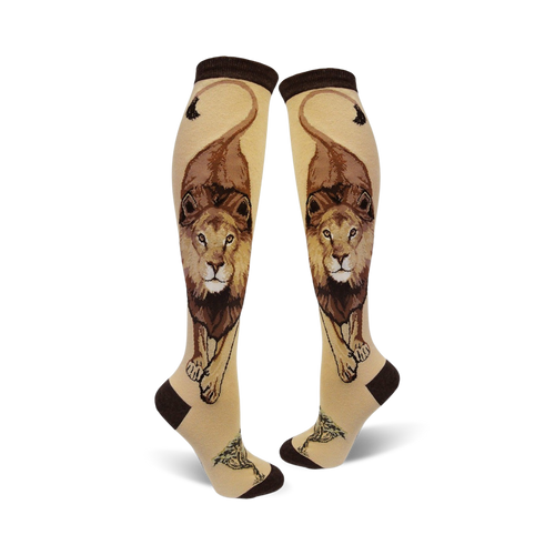 Pair of cream knee-high socks with a detailed brown lion design, including its mane and tail, and small tree accents at the bottom.