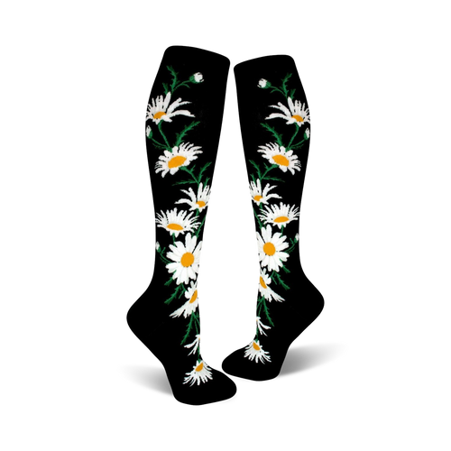 A pair of black knee-high socks with a whimsical pattern of white daisies and green stems.