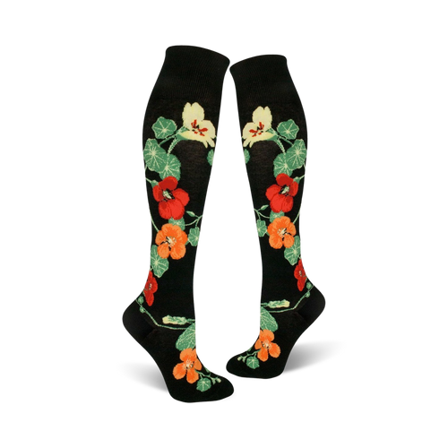 Pair of black knee-high socks with a pattern of orange, red, and yellow nasturtium flowers and green leaves.
