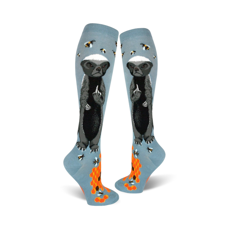 Pair of light blue knee-high socks with a honey badger giving the middle finger, bees, and honeycomb design.