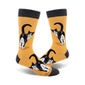 Pair of crew socks; mustard yellow and charcoal grey; featuring a tuxedo cat's rear end, repeated pattern.