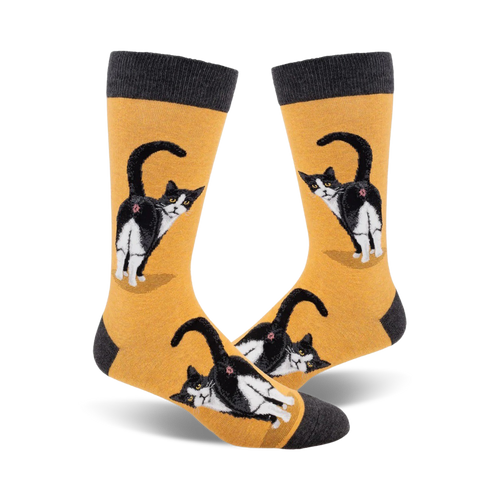 Pair of crew socks; mustard yellow and charcoal grey; featuring a tuxedo cat's rear end, repeated pattern.