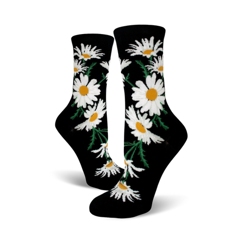 A pair of black crew socks featuring a whimsical pattern of white daisies with yellow centers and green stems.