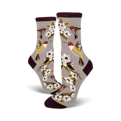 Pair of grey crew socks with colorful hummingbirds and white flowers. Dark maroon band at the top.