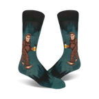 Pair of teal crew socks depicting a Bigfoot character enjoying a beer in a forest setting. Darker teal and black accents.