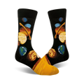 A pair of crew socks with a black background displaying a colorful illustration of the planets in our solar system. Yellow accents at the bottom.
