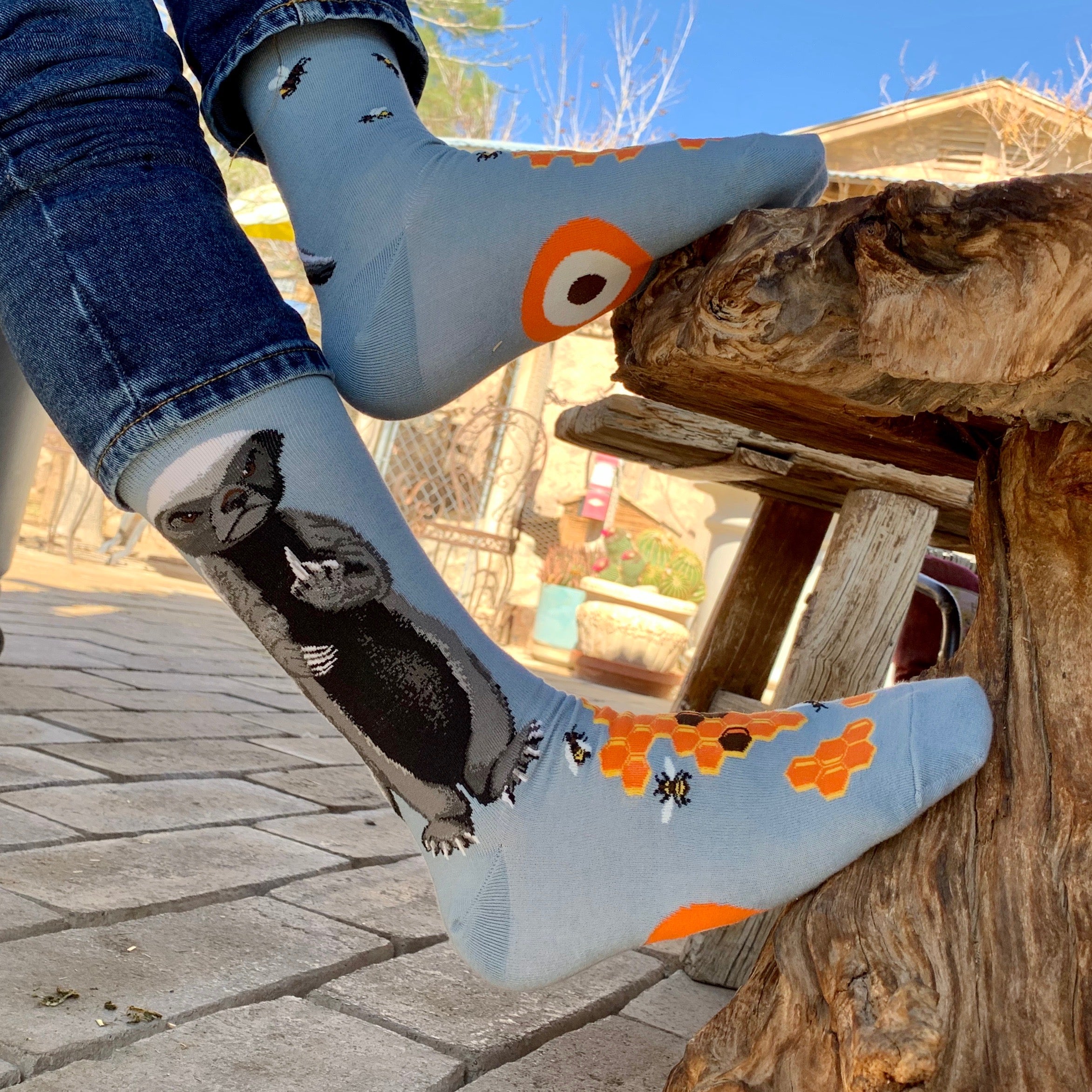 Lifestyle shot of Honey Badger socks being worn outdoors. Shows the socks on a person's feet in a different outdoor setting. [lf]