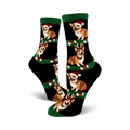 Crew socks with black background and green stripes.  Features repeating images of corgis wearing Santa hats and reindeer antlers.