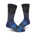 Pair of crew socks in navy blue and dark teal.  Constellation design fades into a forest scene at the bottom.