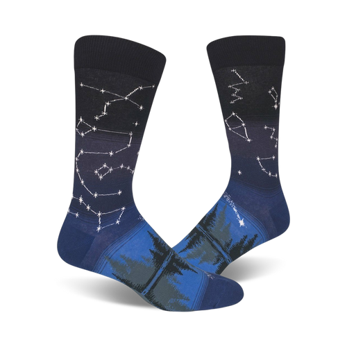 Pair of crew socks in navy blue and dark teal.  Constellation design fades into a forest scene at the bottom.