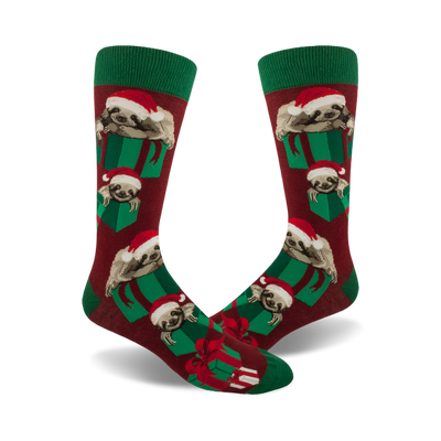 pair of men's crimson crew socks; front view.  features a repeating pattern of sloths wearing santa hats and nestled in green christmas presents.